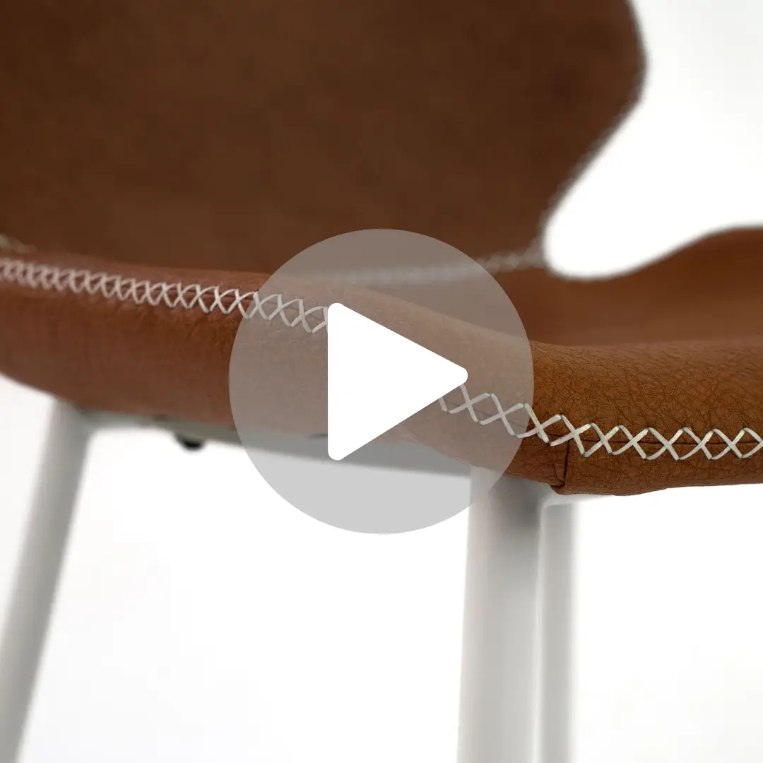 תקריב של כיסא עור מלאכותי חום ALEX CAMEL כולל תפרים צולבים לבנים בשולי המושב. אידיאלי עבור פינות אוכל (כסאות דמוי עור לפינת אוכל), יש לו רגליים לבנות וחלקות. סמל לחצן הפעלה מציין שתצוגה מקדימה של סרטון זמינה.