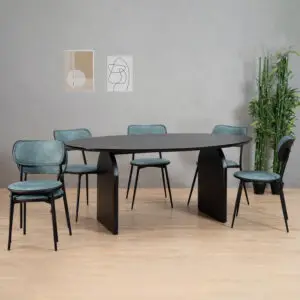חדר אוכל מודרני מציג את LAPI פינת אוכל אובלית, שולחן שחור אובלי עם רגליים מעוקלות, מוקף בשישה כיסאות מרופדים בצבע צהבהב. שתי יצירות אמנות מופשטות מקשטות את הקיר האפור, וצמח ירוק גבוה מדגיש את רצפת העץ הבהירה.