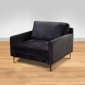 כורסת ARM CHAIR MAMBA, כורסה מודרנית מבד קטיפה אפור כהה עם רגלי מתכת דקיקות, ניצבת על רצפת עץ בהירה על רקע קיר אפור בהיר חלק.