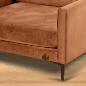 תקריב של כורסת ARM CHAIR MAMBA בצבע חלודה, עם כרית מושב ורגלי מתכת שחורות, המוצבת על רצפת עץ בהירה.