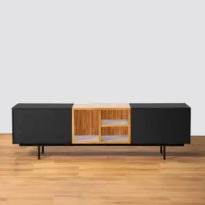 SIDER הוא מעמד טלוויזיה שחור ומודרני עם רגליים דקיקות, מסגרת עץ ומדפים עם חזית זכוכית — אידיאלי עבור מחפשי מזנונים מיוחדים. מוצג כאן על רצפת עץ מול קיר אפור בהיר.